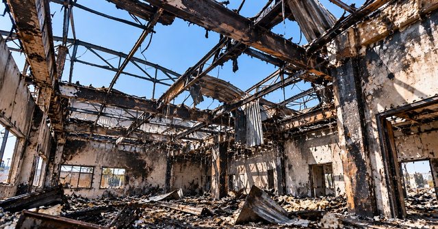Fire-gutted building structure with collapsed roof — fire & property loss survey